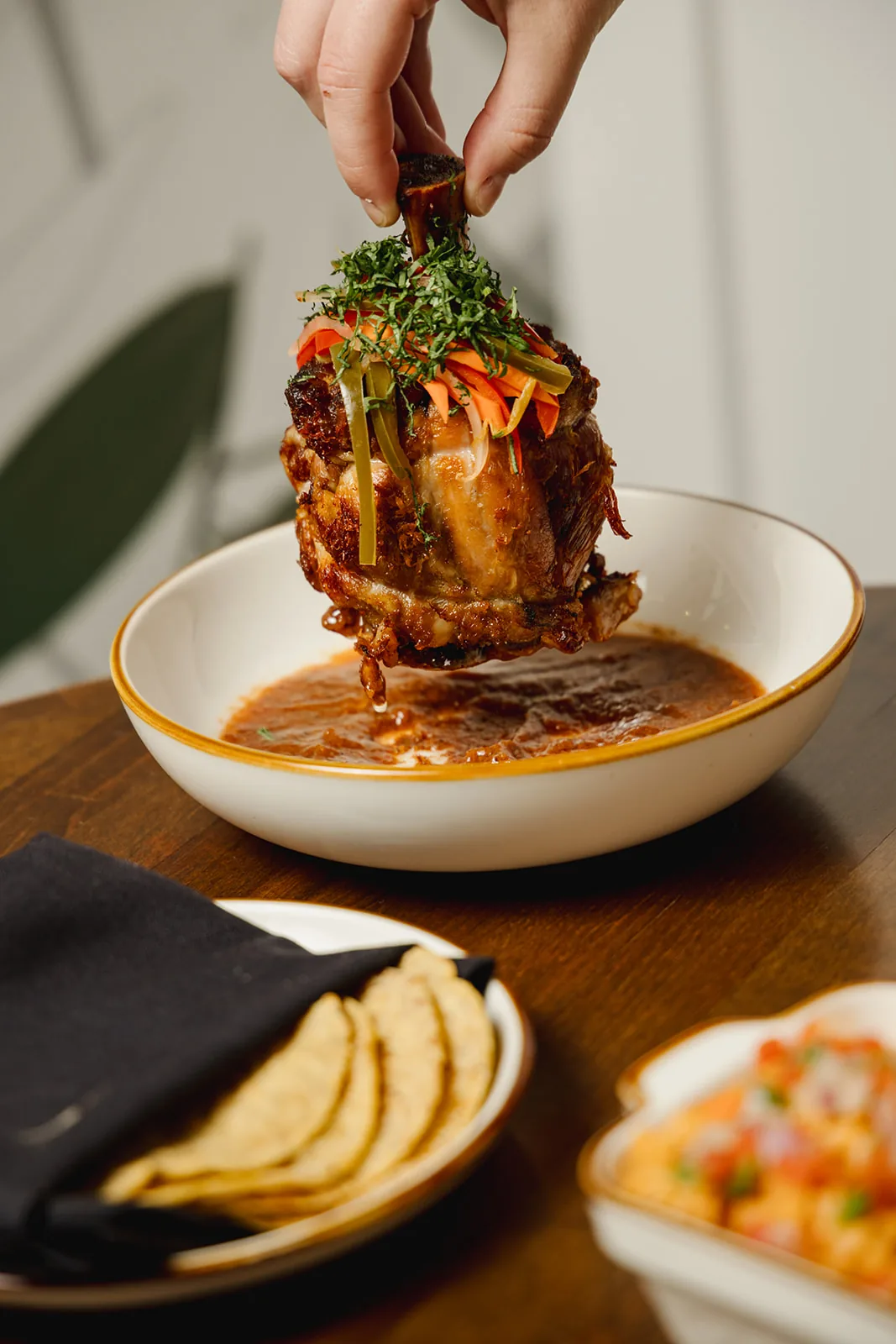 Birria-style lamb shank in consomé, served with handmade tortillas